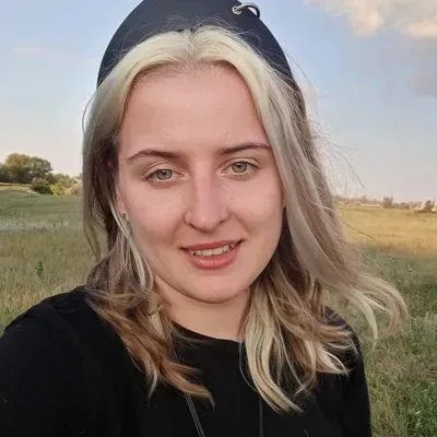Молодая женщина с длинными светлыми волосами, на природе, на фоне поля и неба